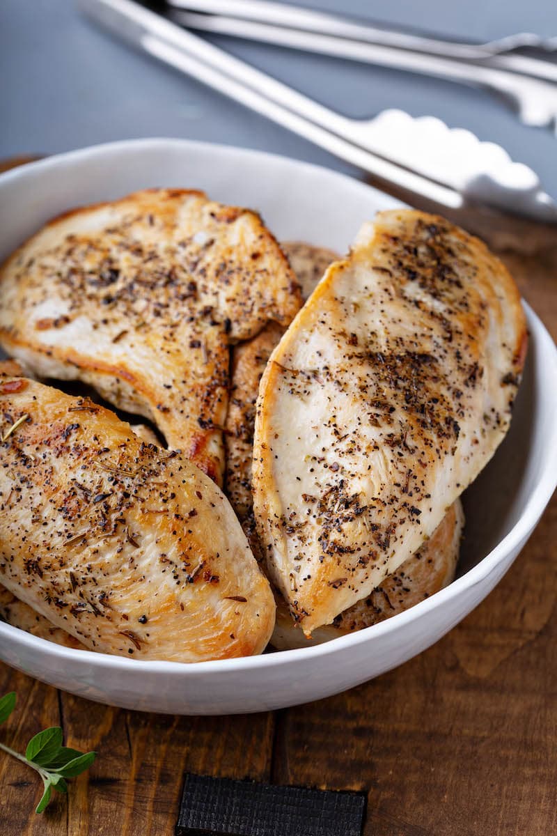 Sauteed seasoned chicken breasts in a skillet. 