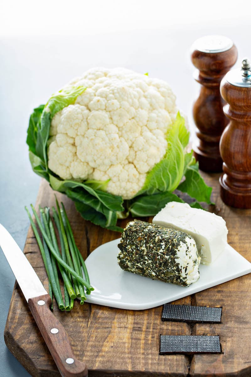 Cauliflower, herbed goat cheese, cream cheese and chives on a platter.