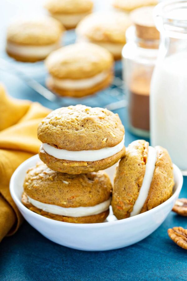 Carrot Cake Whoopie Pies: two pillowy soft carrot cake cookies are filled with a sweet cream cheese frosting! It’s like your favorite carrot cake in an easily transportable form! #WhoopiePies #CarrotCake #Dessert #Easter #CreamCheese #CarrotCakeWhoopiePies