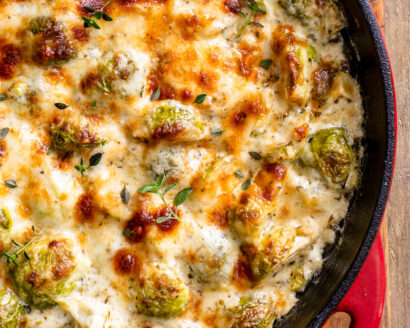 Creamy baked brussel sprouts in a cast-iron pan.