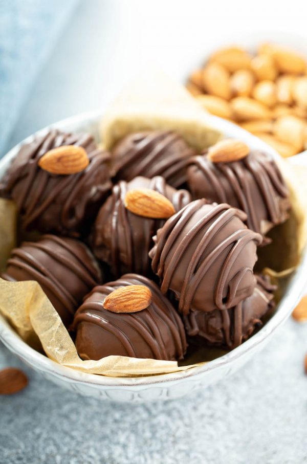A Big Bowl Filled with Almond Joy Truffles in Front of a Small Bowl of Almonds
