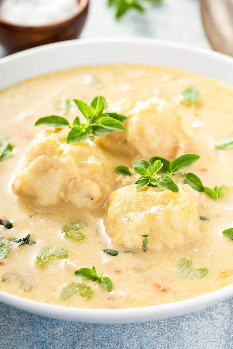 Crockpot chicken and dumplings in a large white bowl.