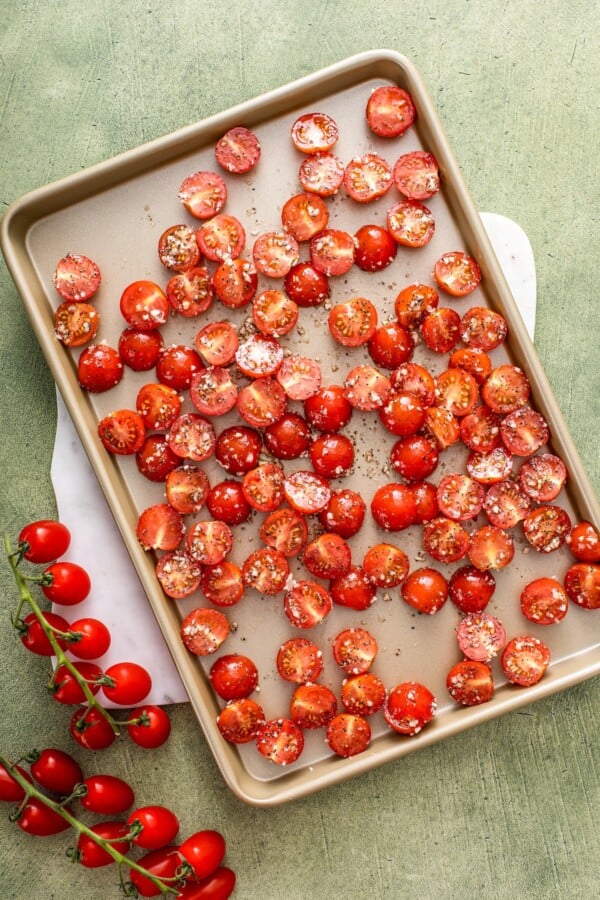 Spreading the cherry tomatoes in the baking tray.