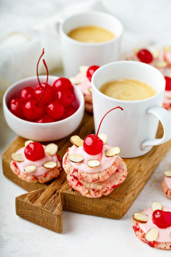 Maraschino Cherry Cookies with almonds and pink frosting with a cup of coffee. 