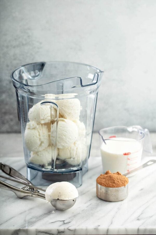 Vanilla ice cream in a blender with milk, chocolate milk powder and powdered sugar.