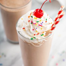 Chocolate Frosty with whipped cream, sprinkles and a cherry.