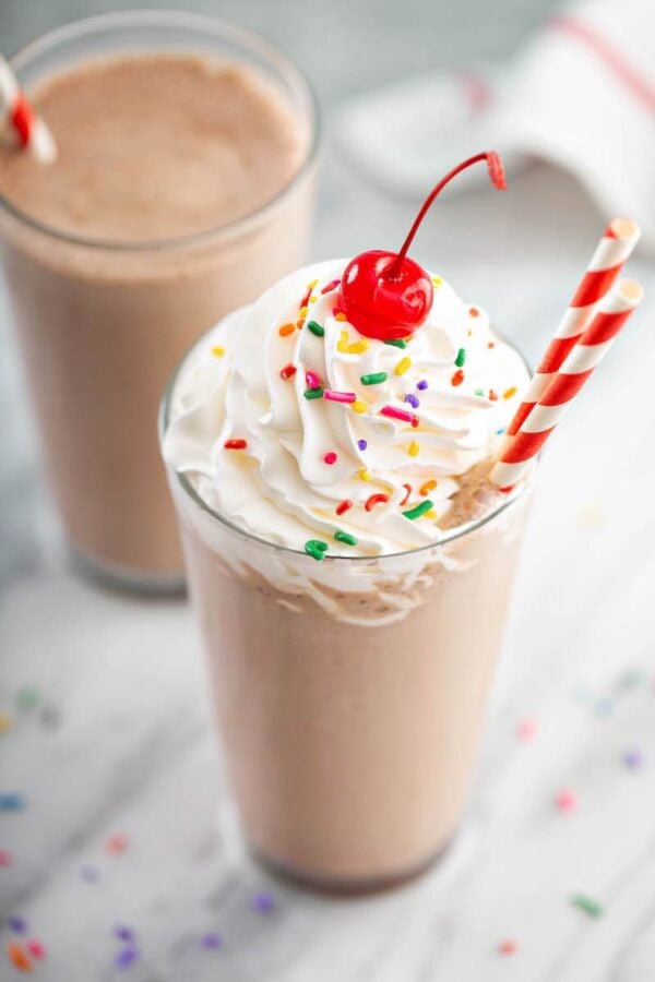 Chocolate Frosty with whipped cream, sprinkles and a cherry. 