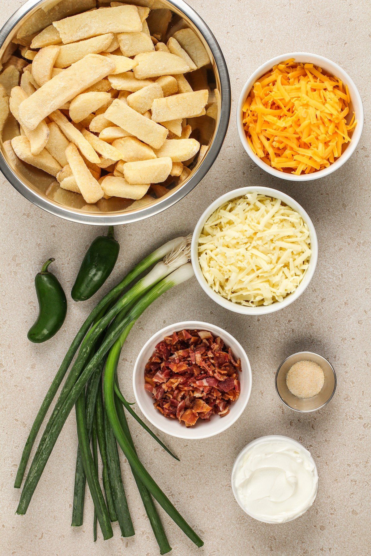 From top: Frozen steak fries, cheddar cheese, monterey jack cheese, bacon, seasoned salt, sour cream, green onion, jalapeno.