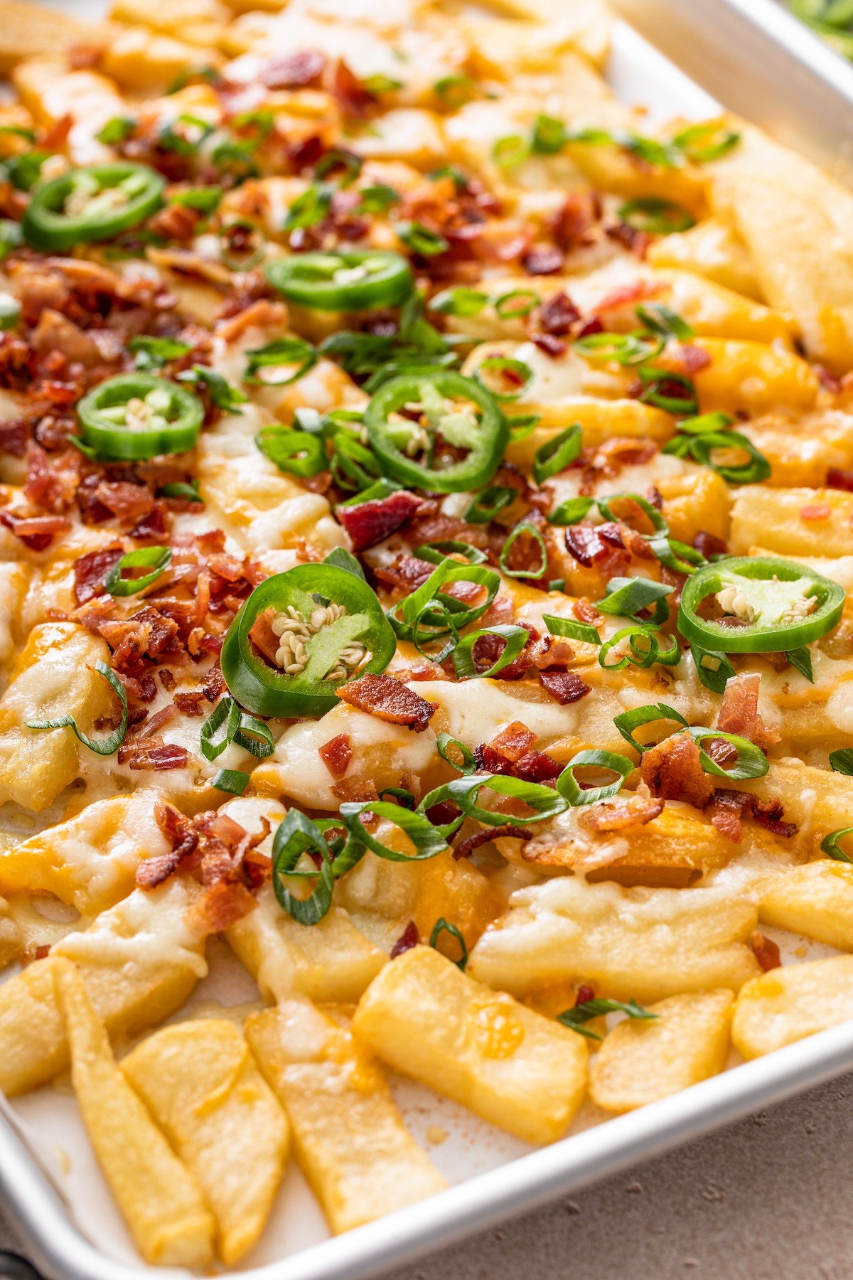 Close-up of Texas cheese fries on a baking sheet.