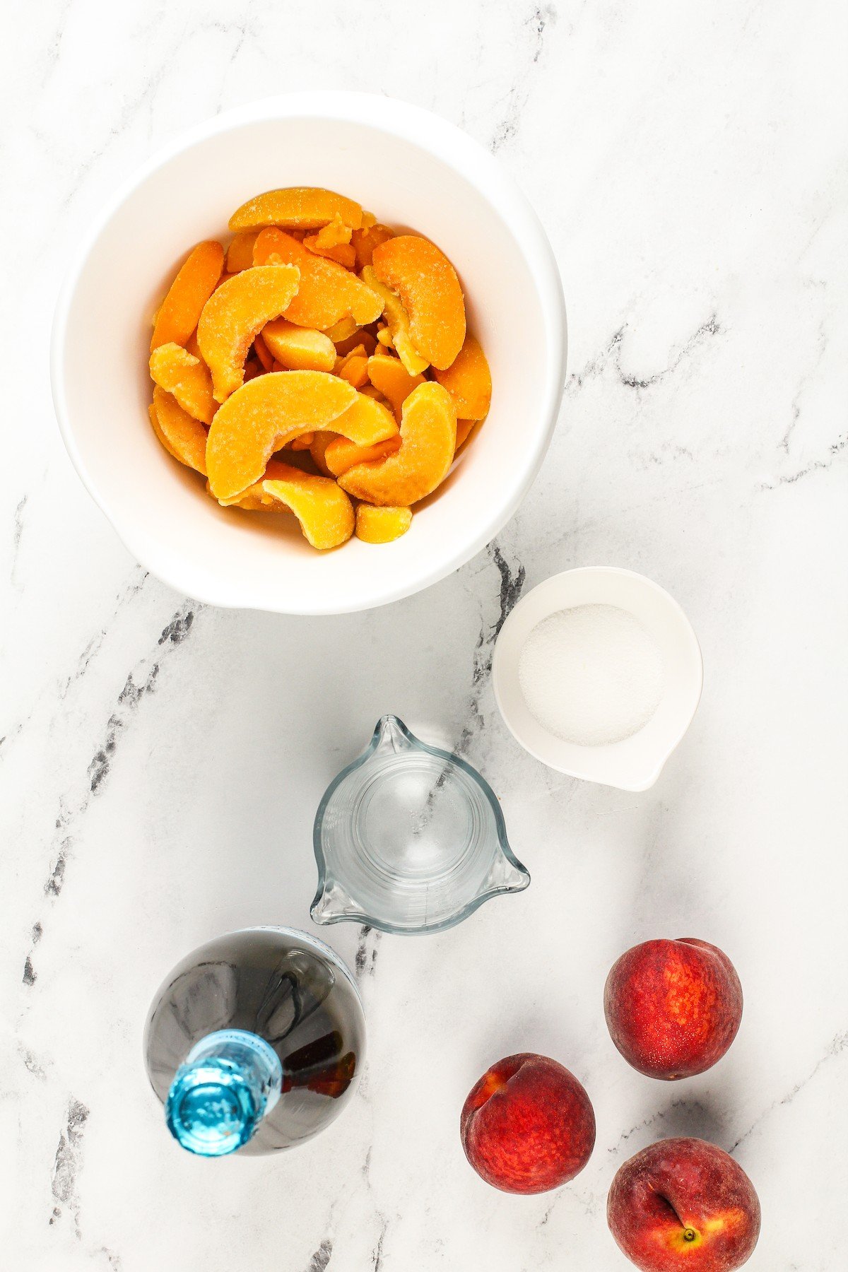 Frozen peach bellini ingredients arranged on a work surface.