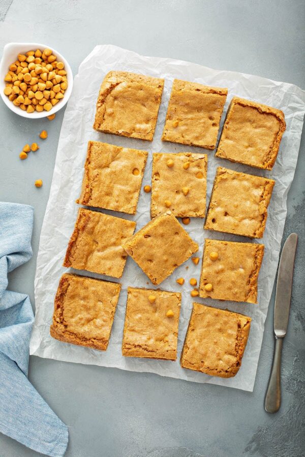 Butterscotch blondies sliced into squares on a parchment paper.