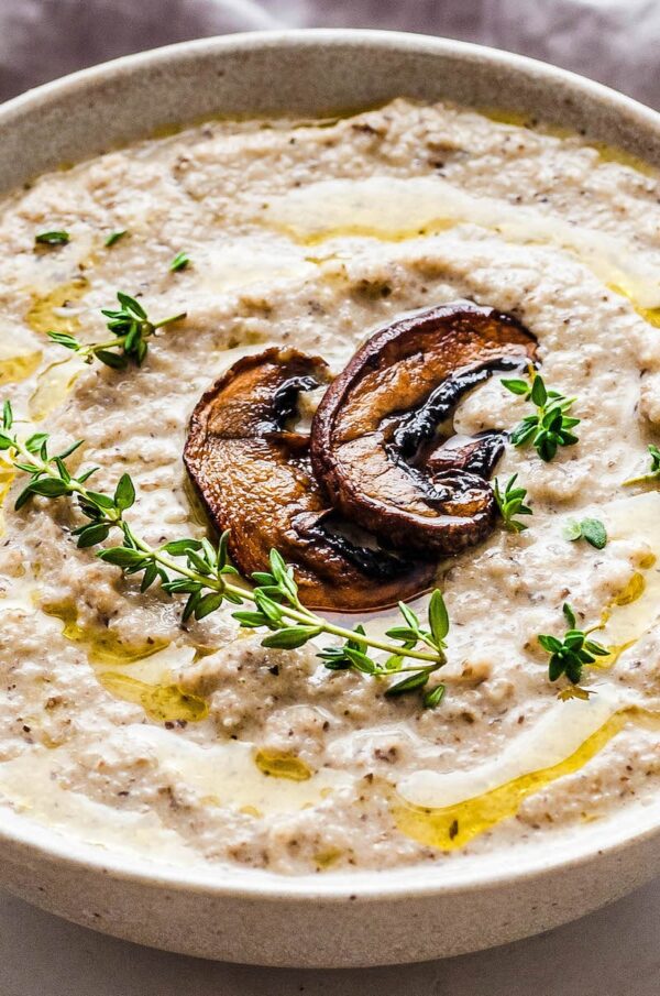 Mushroom Soup in a white bowl with roasted mushrooms on top.
