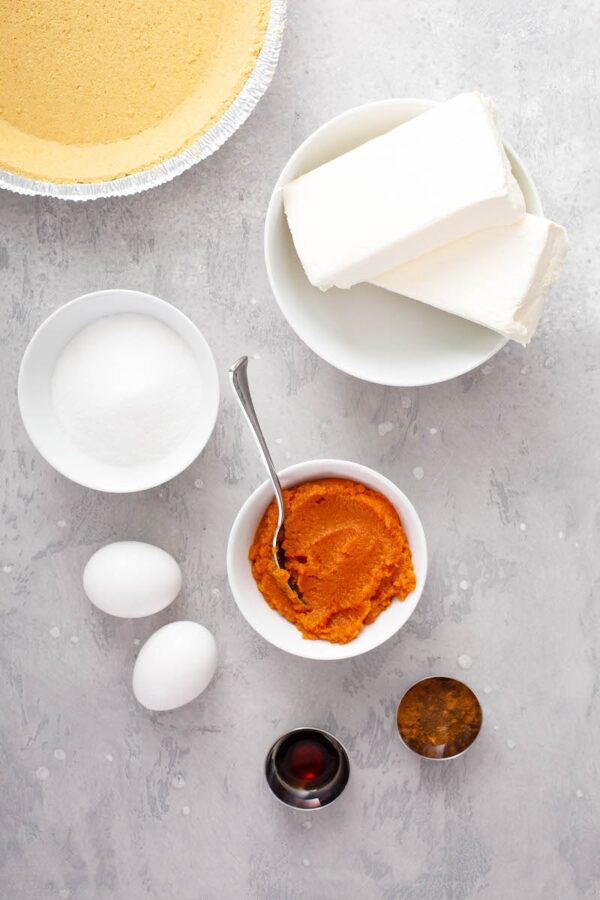 Ingredients for Pumpkin Pie Cheesecake in bowls.