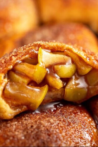 Apple Pie Bombs made with canned biscuits stacked. Top 'bomb' shows gooey apple caramel center.