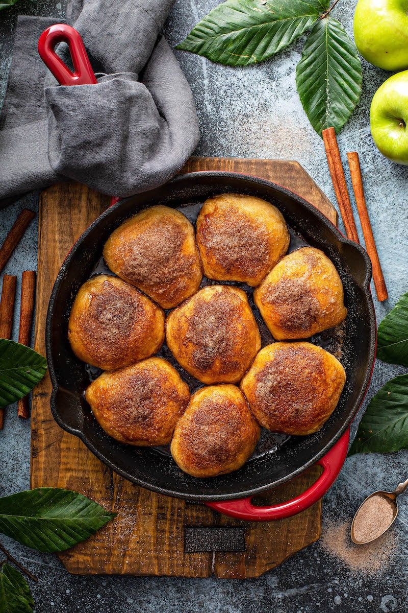 Apple pie bombs in a cast iron skillet.