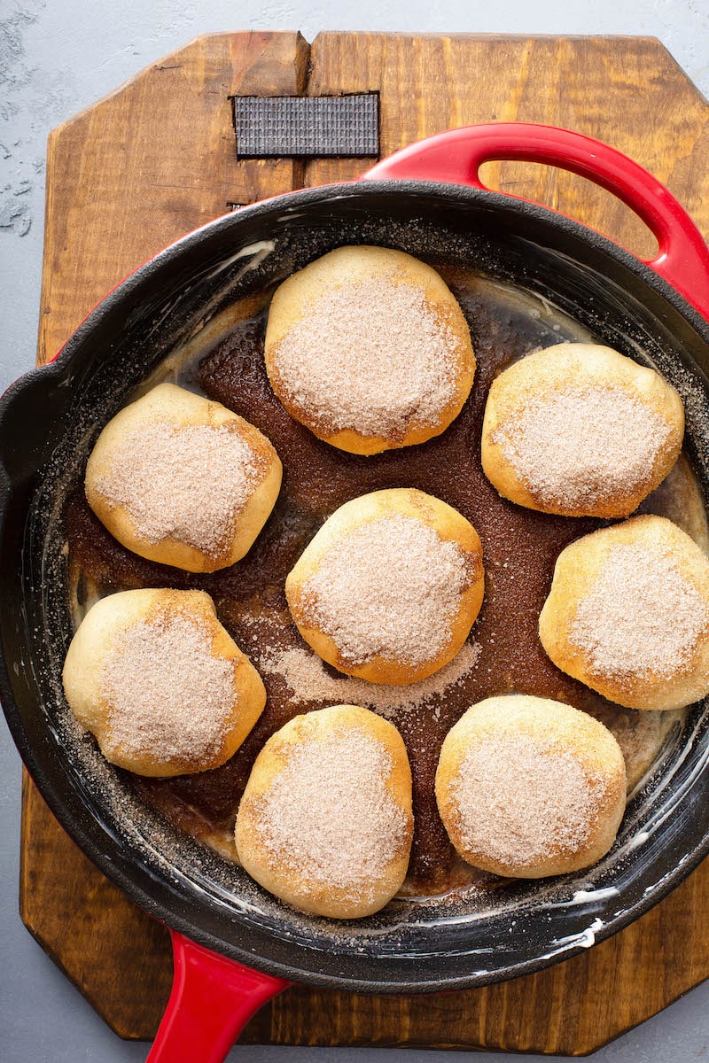 Apple Pie Bombs in skillet before baking with cinnamon sugar topping.