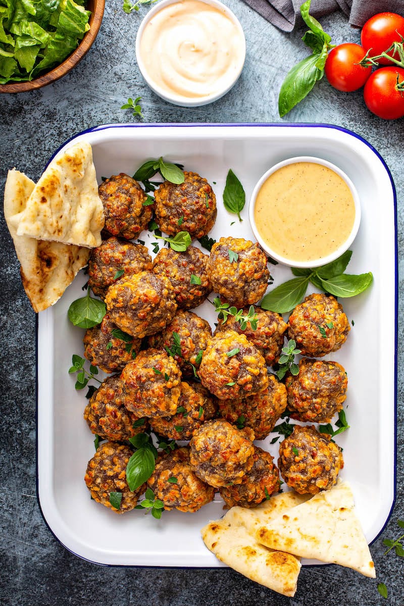 Bisquick Sausage Balls with sauce served in a white dish.