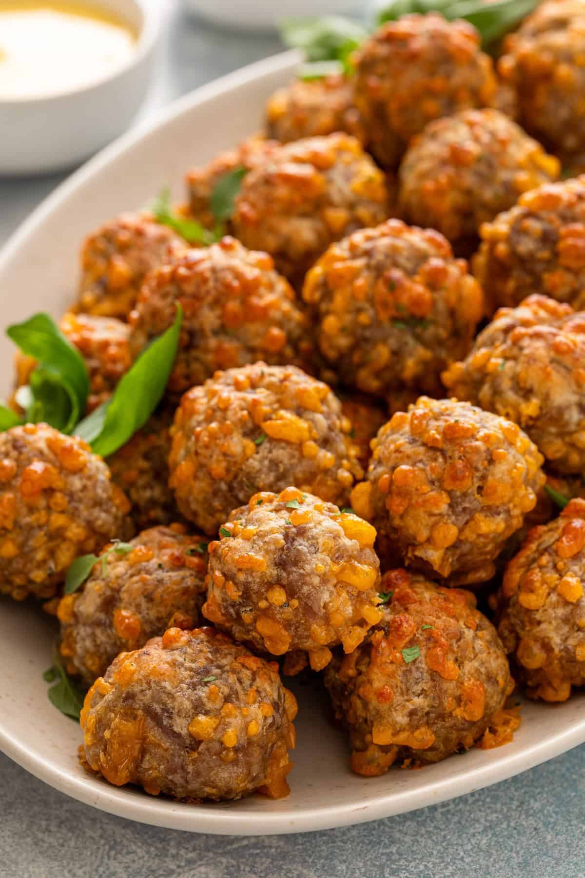 Sausage balls with bisquick presented on a white serving dish.