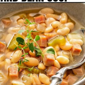 A spoon is placed in a bowl of savory slow cooker ham and bean soup.