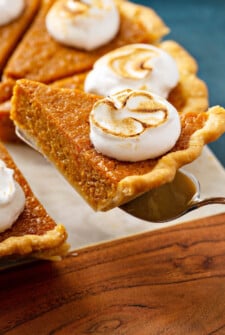 A slice of sweet potato pie being lifted by a pie cutter.