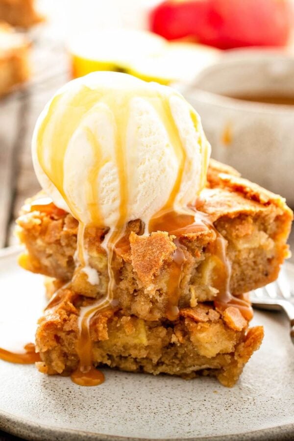 Apple Blondies on a plate with vanilla ice cream and caramel sauce.