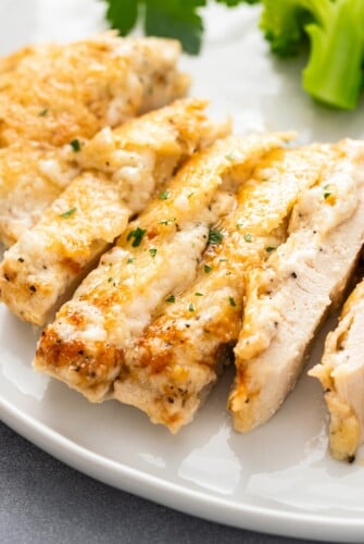 A sliced parmesan chicken breast is cooked all the way through.