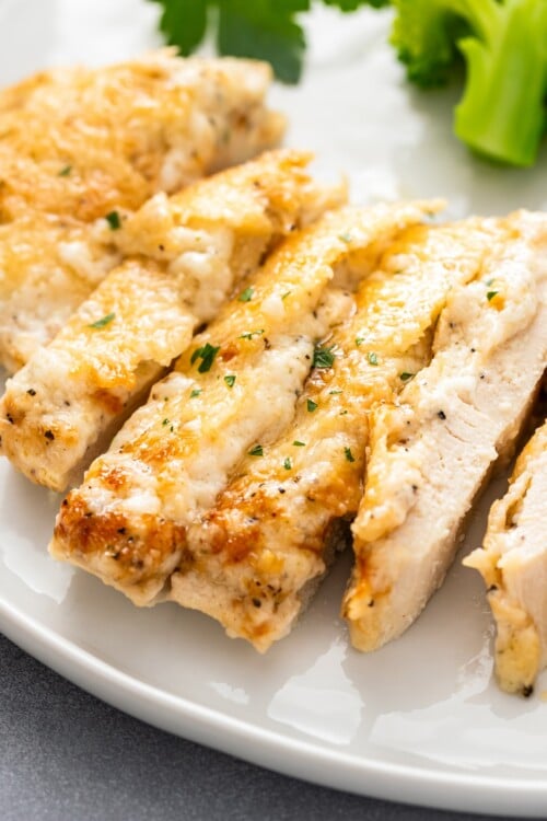 A sliced parmesan chicken breast is cooked all the way through.