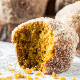 Donut Pumpkin Muffins with a bite taken out of it.