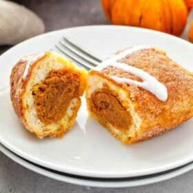 These sweet Pumpkin Pie Bombs are canned biscuits stuffed with pumpkin pie filling, baked with a cinnamon sugar topping and served with a cream cheese drizzle! #Pumpkin #PumpkinPie #PumpkinPieBombs #PumpkinRecipes #PumpkinDessert #Recipe #FallRecipes