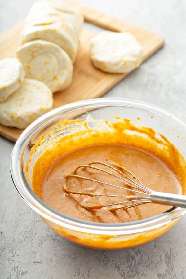 Filling for Pumpkin Pie Bombs in a a glass bowl with a whisk.