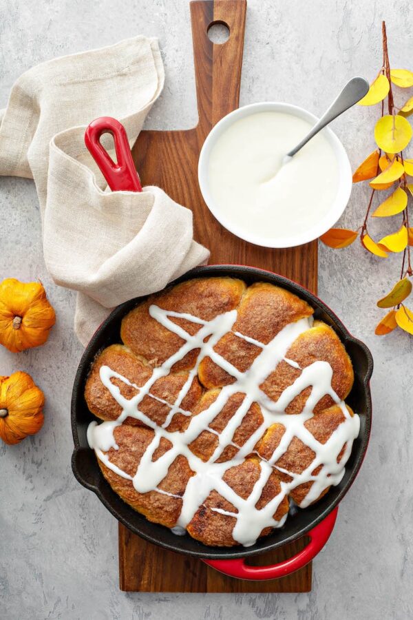 Pumpkin PIe Bombs in a cast iron skillet with cream cheese drizzle.