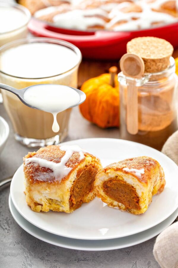 Pumpkin PIe Bombs being drizzled with cream cheese icing. 