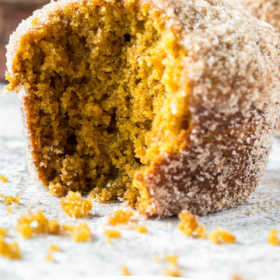 Pinterest image of donut pumpkin muffin with a bite taken out of it.