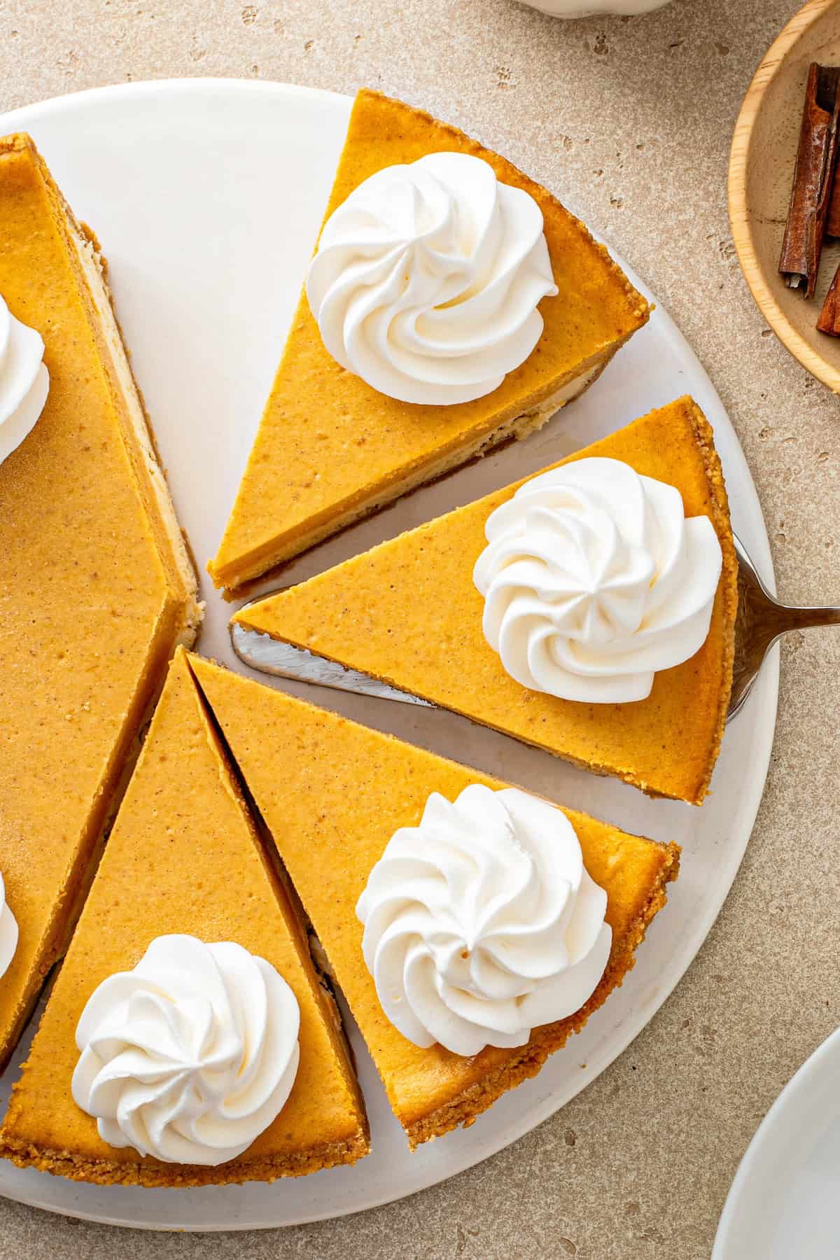 Several slices of cheesecake pumpkin pie are on a serving plate.