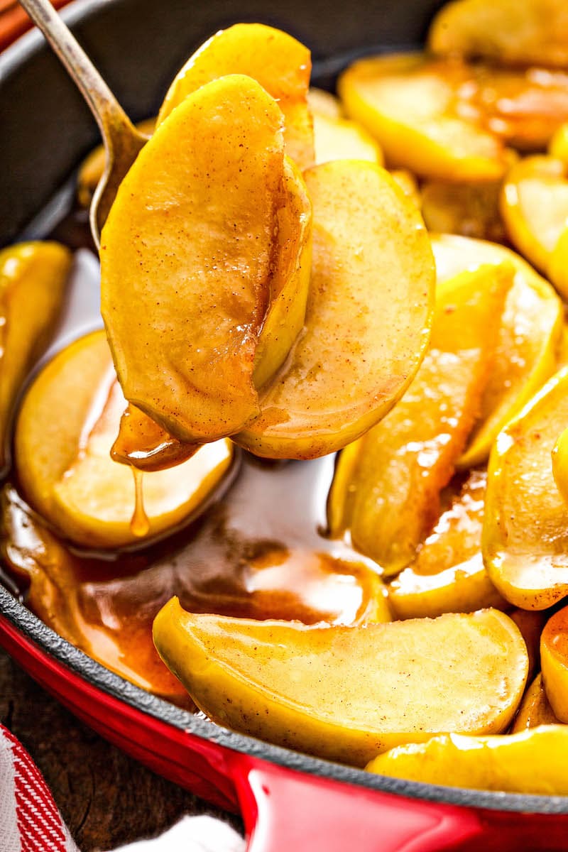 Apple slices cooked in a skillet with butter and brown sugar.