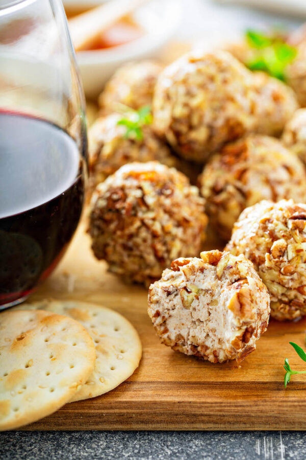 Honey Pecan Cheese Ball recipe on a wood cutting board for holiday appetizers.