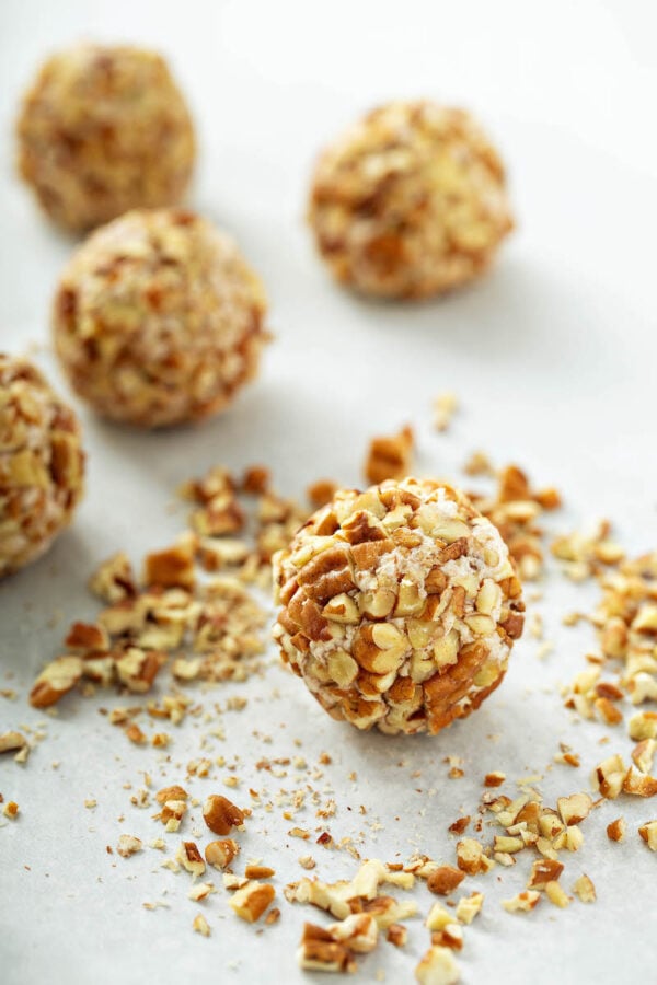 Honey Pecan Cheese Ball Recipe on parchment paper after rolling in pecans.