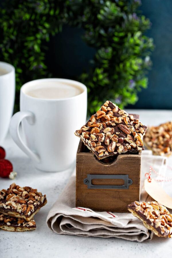 Pecan Christmas Crack in a box with a cup of coffee.