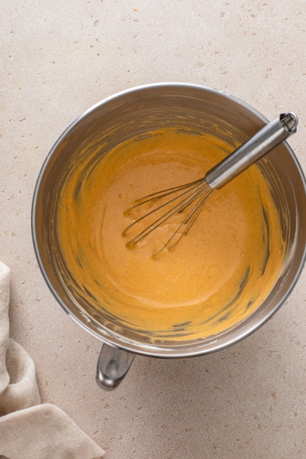 Pumpkin pie mixture is whipped up in a mixing bowl.