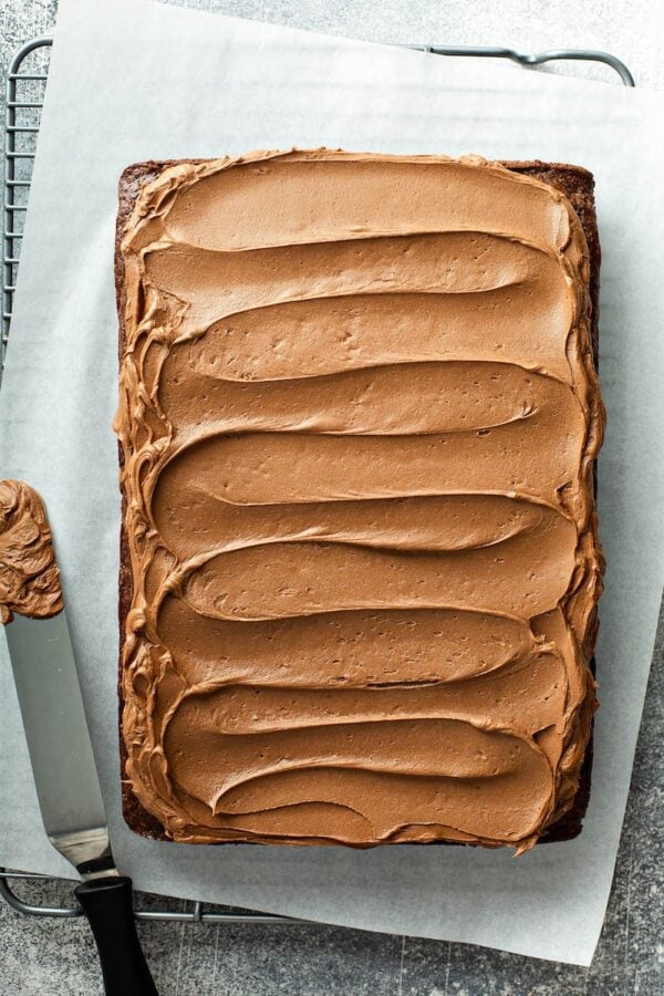 Fluffy whipped chocolate icing spread on top of chocolate cake.