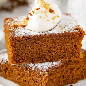 Gingerbread stacked in two big thick slices with whip cream on top.