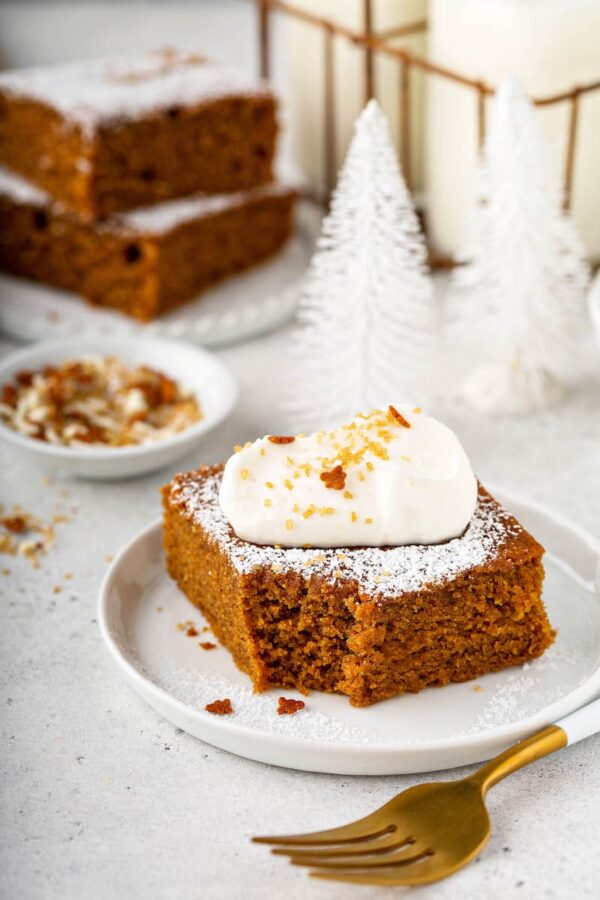 Gingerbread on a plate with a bite taken out of it.