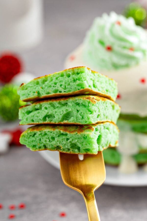 Three bites of Grinch Pancakes stacked on top of each other on a fork.