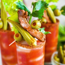 A fully loaded Bloody Mary mix garnished with olives, okra, and a pork rib.