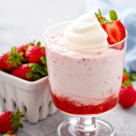 Strawberry Mousse in a glass jar with a strawberry on top.