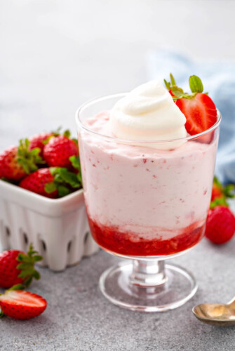 Strawberry Mousse in a glass jar with a strawberry on top.