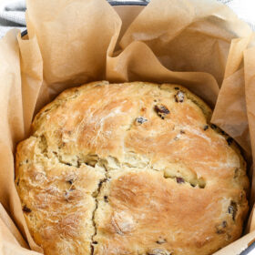 Loaf of Irish Soda Bread in a Dutch Oven on Parchment Paper.