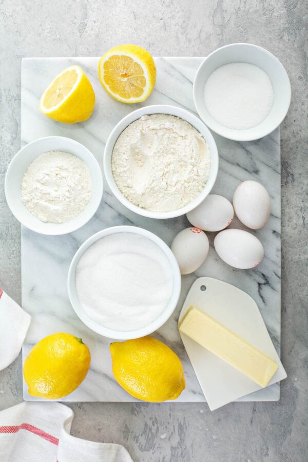 Ingredients for lemon bars in white bowls.