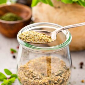 Spoon and jar with Homemade Greek Seasoning