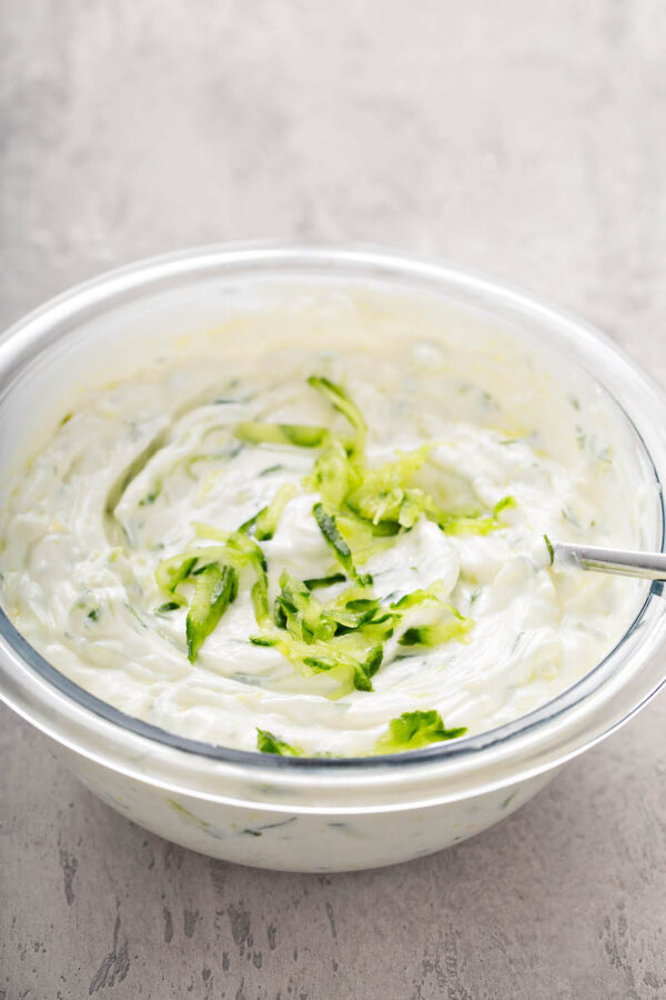 Cucumber dip in a bowl with a spoon